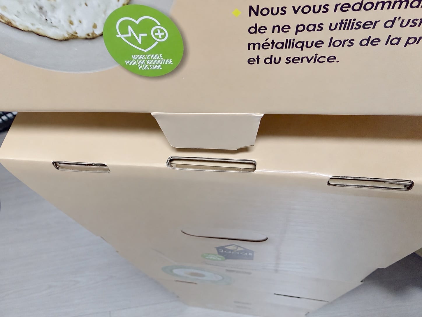 Close-up of die-cut hand slots and printed information on a cookware carton