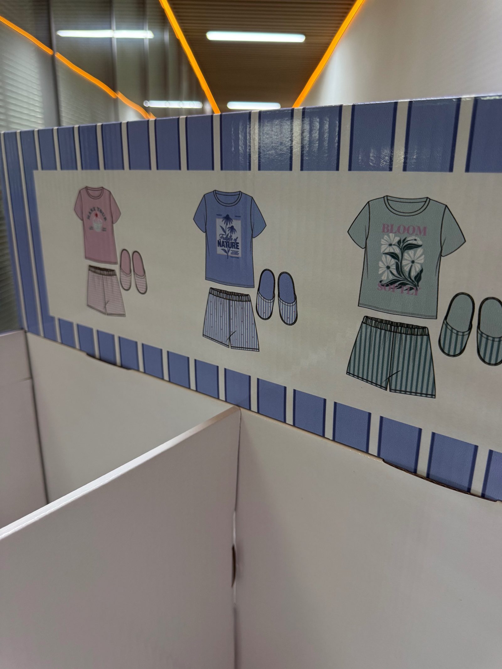 Printed header board of the pyjama floor display showing pyjama set artwork